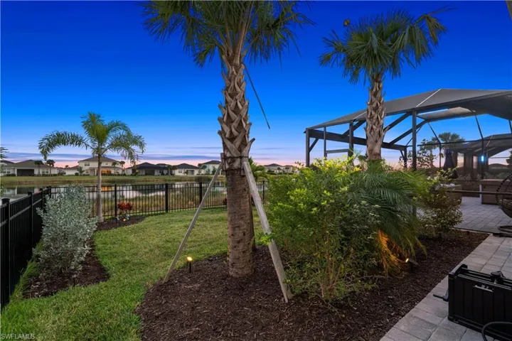 Yard at dusk with a lanai, a sunroom, a residential view, a patio, and a fenced backyard
