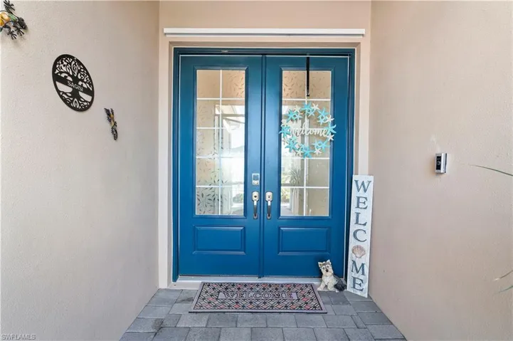 Doorway to property featuring french doors and stucco siding