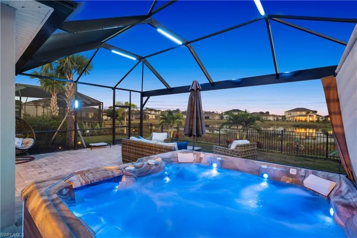 Pool at dusk featuring a sunroom, a pool, glass enclosure, and a fenced backyard