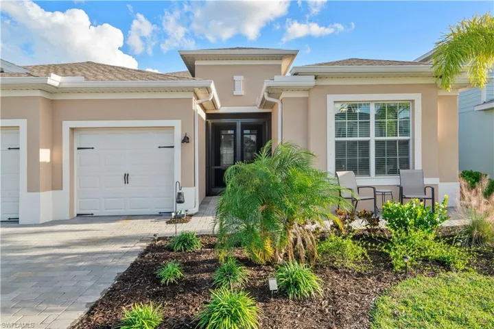 View of front of home featuring stucco siding, decorative driveway, and a garage