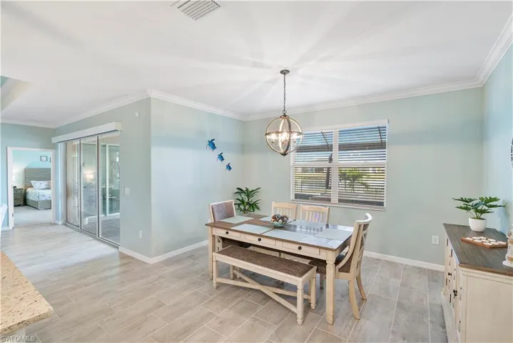 Dining room featuring ornamental molding, wood finish floors, and hanging lights