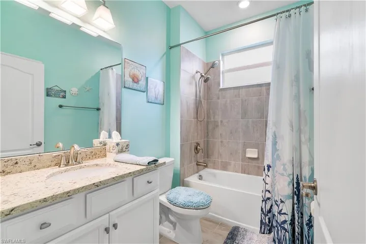 Full bathroom with vanity, shower / bathtub combination with curtain, and light wood-type flooring