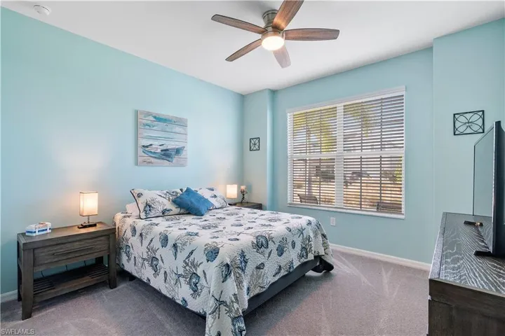 Carpeted bedroom featuring baseboards and ceiling fan
