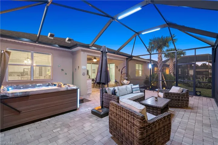 View of patio with glass enclosure, a sunroom, a hot tub, and outdoor lounge area