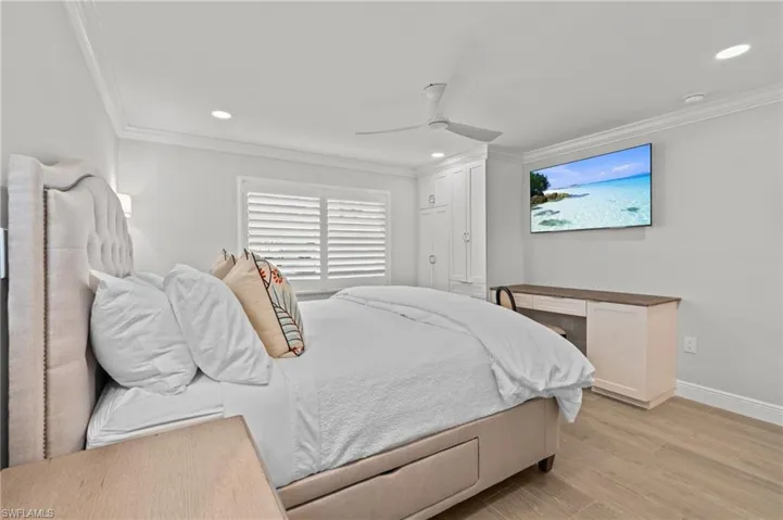 Bedroom with light wood-style flooring, crown molding, a ceiling fan, and recessed lighting