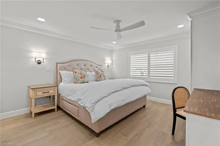 Bedroom featuring light wood-type flooring, ornamental molding, a ceiling fan, and recessed lighting
