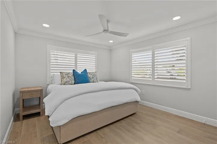 Bedroom with crown molding, light wood-style flooring, ceiling fan, and recessed lighting