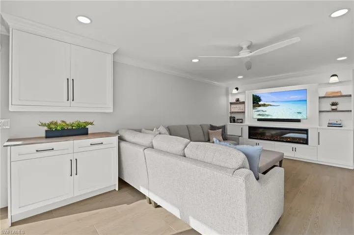 Living area featuring light wood-style flooring, recessed lighting, ceiling fan, and crown molding