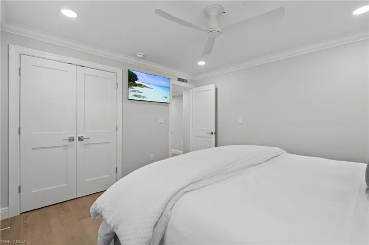 Bedroom with wood finished floors, ornamental molding, recessed lighting, a closet, and a ceiling fan