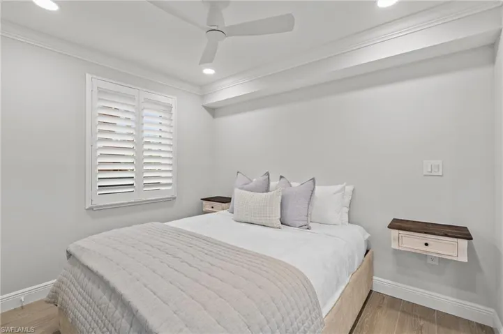 Bedroom featuring light wood-style floors, crown molding, ceiling fan, and recessed lighting
