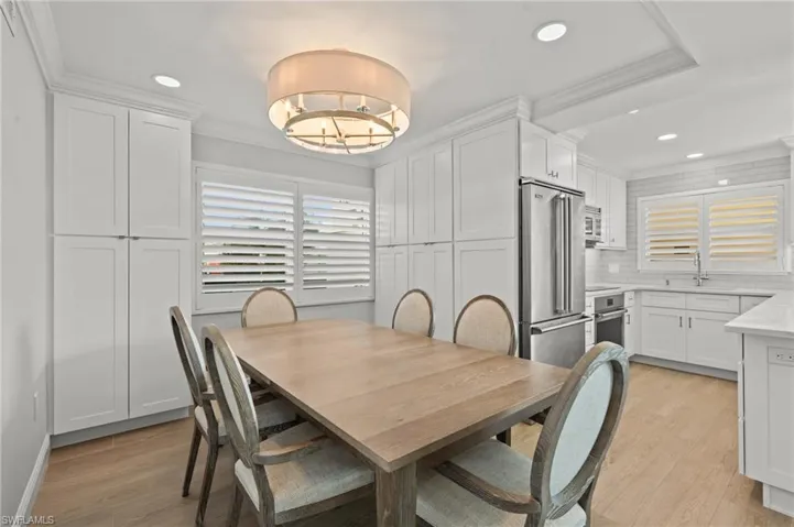 Dining space with crown molding, light wood-style flooring, recessed lighting, and a chandelier