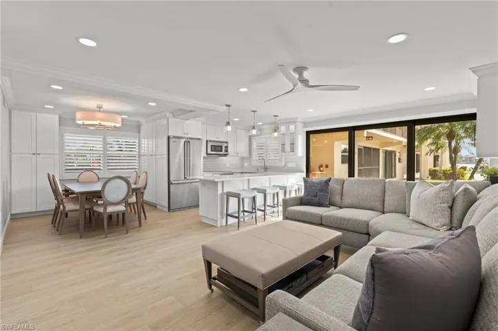 Living area featuring crown molding, light wood-style floors, recessed lighting, and a ceiling fan
