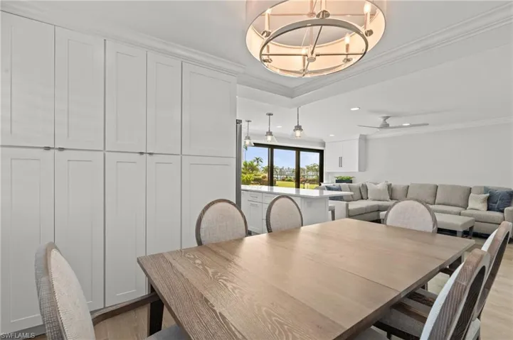 Dining space with a chandelier, crown molding, wood finished floors, recessed lighting, and ceiling fan
