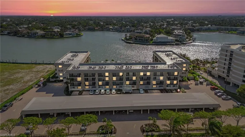 Aerial view at dusk of a water view and a view of apartment building / complex