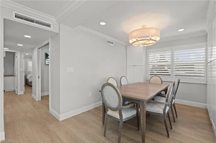 Dining room featuring crown molding, light wood-style floors, and recessed lighting