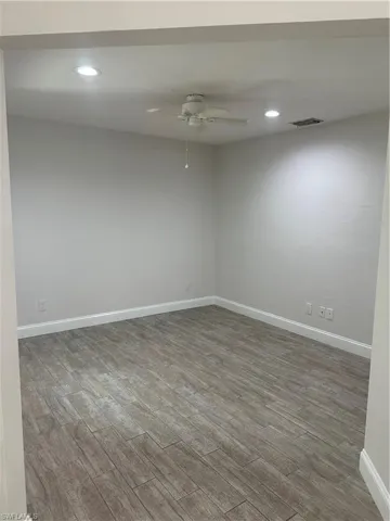 Wood-finish flooring, recessed lighting, ceiling fan, and white baseboards