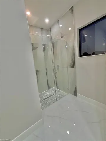 Bathroom with a marble finish shower, marble tiled flooring, and recessed lighting