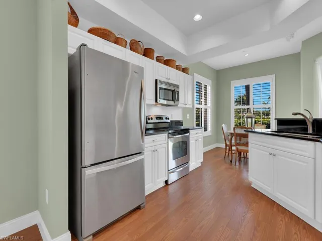 Kitchen featuring sink, white cabinets, stainless steel appliances, and light hardwood / wood-style floors