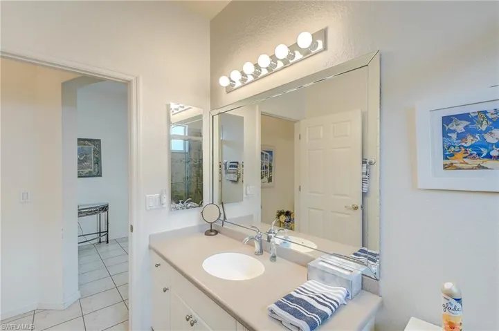 Bathroom featuring vanity, light tile patterned floors, and a textured wall