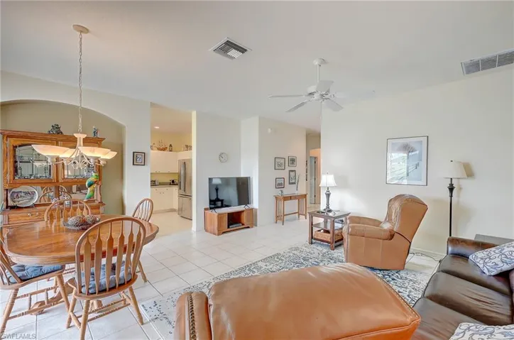 Living room with light tile patterned floors and ceiling fan
