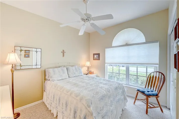 Bedroom featuring multiple windows, ceiling fan, and light colored carpet
