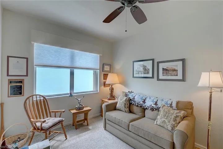 Living room featuring a ceiling fan and light colored carpet