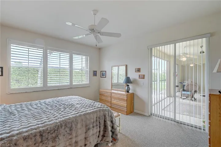 Bedroom featuring light colored carpet, access to exterior, and a ceiling fan