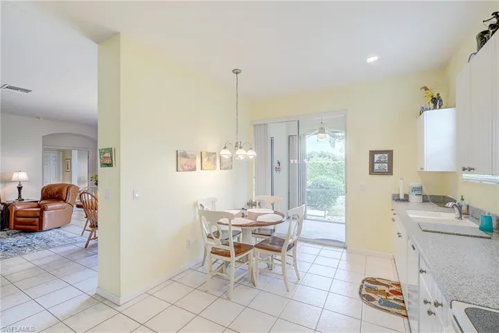 Dining area featuring arched walkways, light tile patterned flooring, and suspended lighting