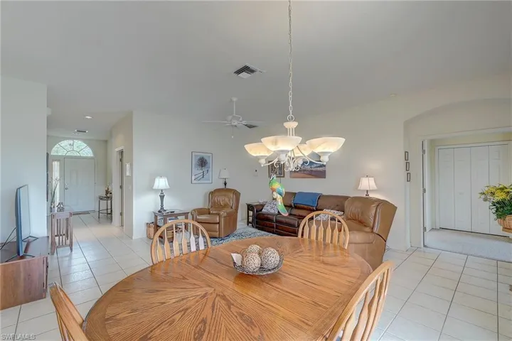 Dining room featuring a chandelier, light tile patterned floors, and ceiling fan