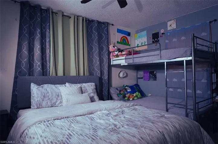 Bedroom with a textured ceiling and ceiling fan