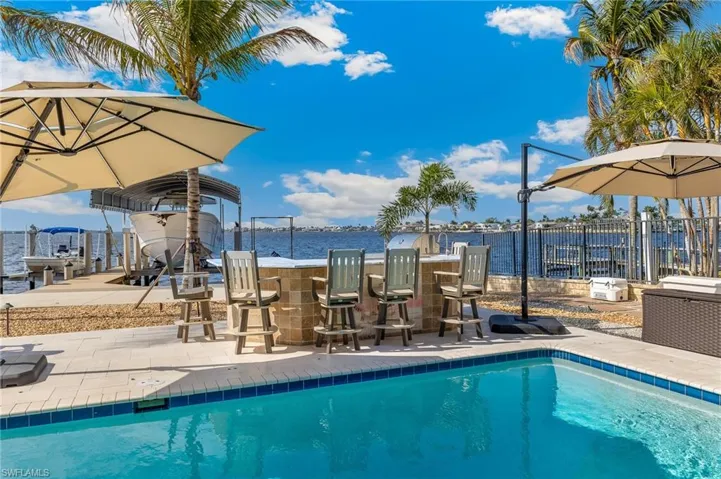 View of swimming pool with a patio area, a dock, fence, outdoor dry bar, and a fenced in pool