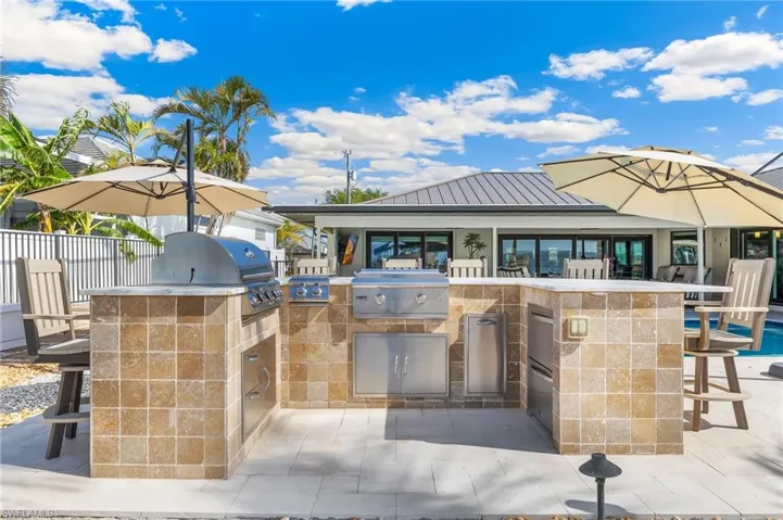 View of patio / terrace with fence, an outdoor kitchen, area for grilling, and outdoor wet bar