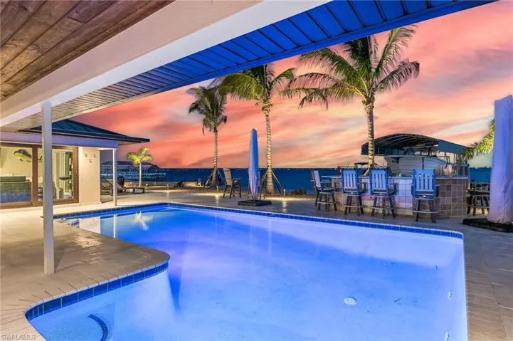 Pool at dusk with an outdoor pool and a patio