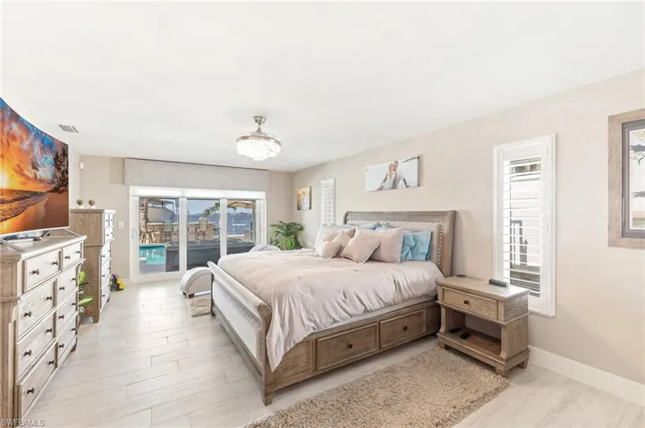 Bedroom with visible vents, light wood-type flooring, access to outside, and baseboards