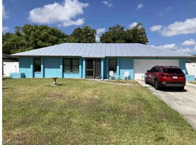 Ranch-style home with a porch, a garage, and a front lawn