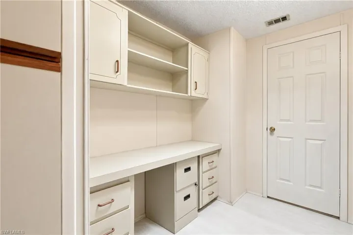 Built-in desk with overhead cabinetry and shelving, complemented by lower drawers and filing storage