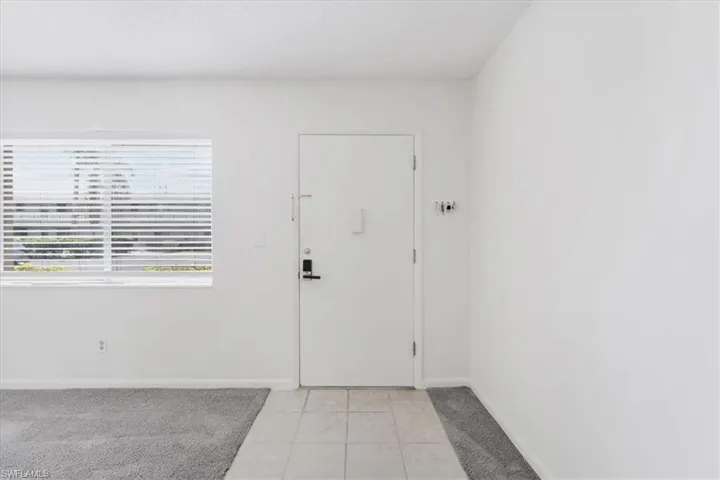 Entryway with light tile patterned flooring and baseboards
