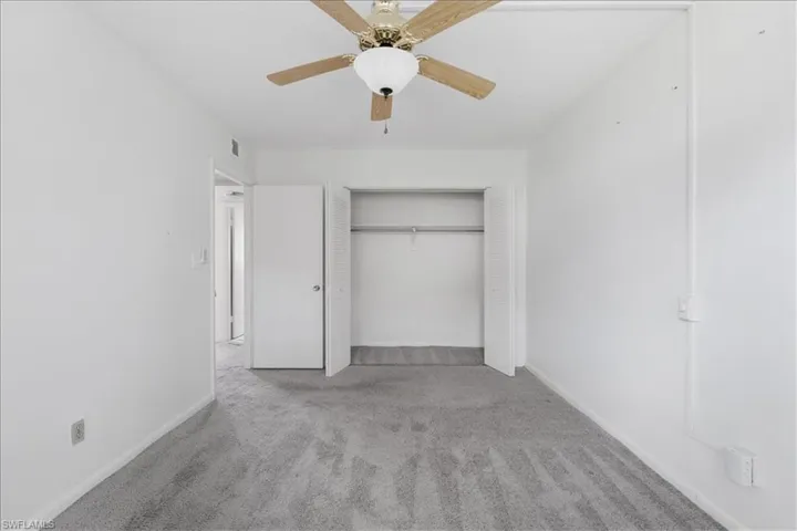 Unfurnished bedroom with carpet flooring, a ceiling fan, and a closet