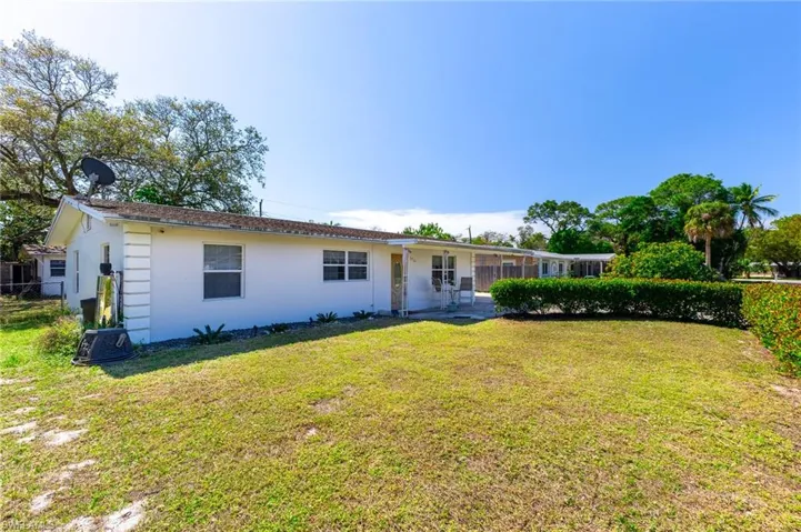 View of front of house featuring a front lawn, fence, and stucco siding