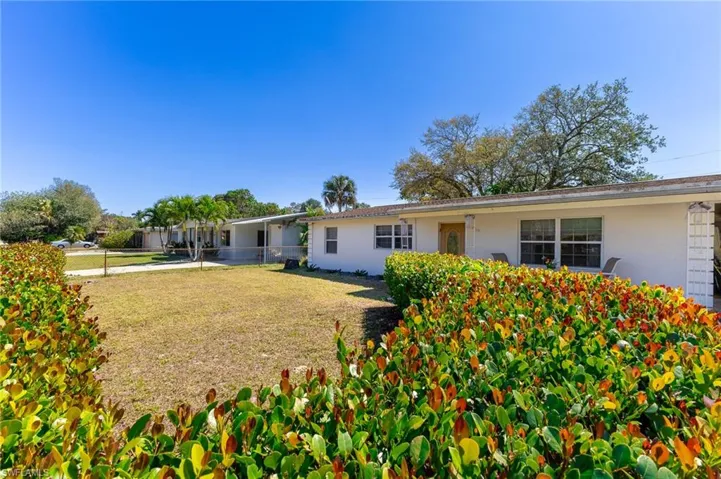 View of front of house featuring a front yard, fence, and stucco siding