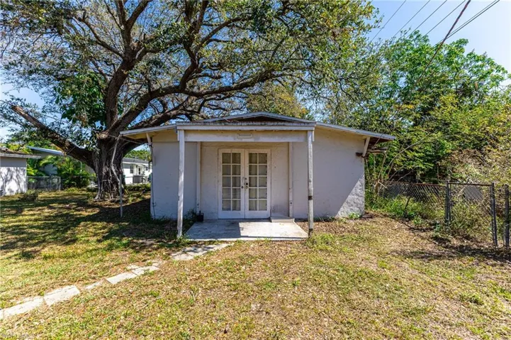 View of outdoor structure with french doors, fence, and an outdoor structure