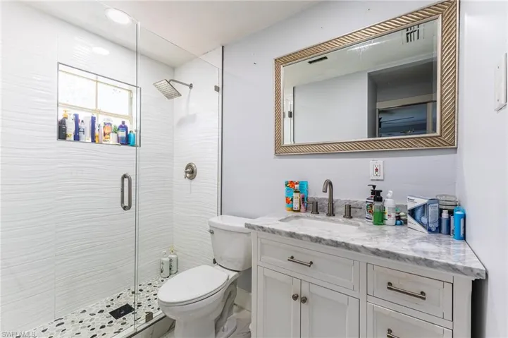 Full bathroom with a stall shower, vanity, and toilet