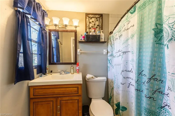 Full bathroom with a wealth of natural light, curtained shower, vanity, and toilet