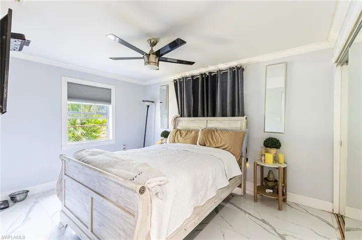 Bedroom featuring baseboards, marble finish floor, and crown molding