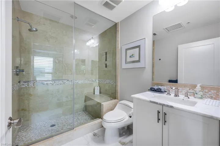 Second Bathroom with vanity, a shower stall, and marble look tile flooring