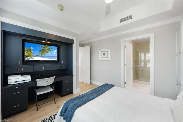 Second Bedroom/ office  featuring light wood-style flooring, a ceiling fan, a desk with built in cabinets  and crown molding