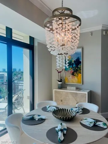 Dining room featuring crown molding, a chandelier, and a view of city