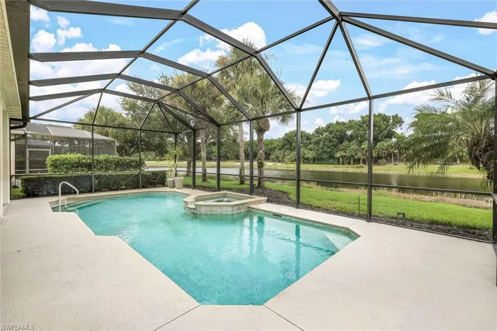View of swimming pool with a patio, an in ground hot tub, and a lanai and golf and water view.