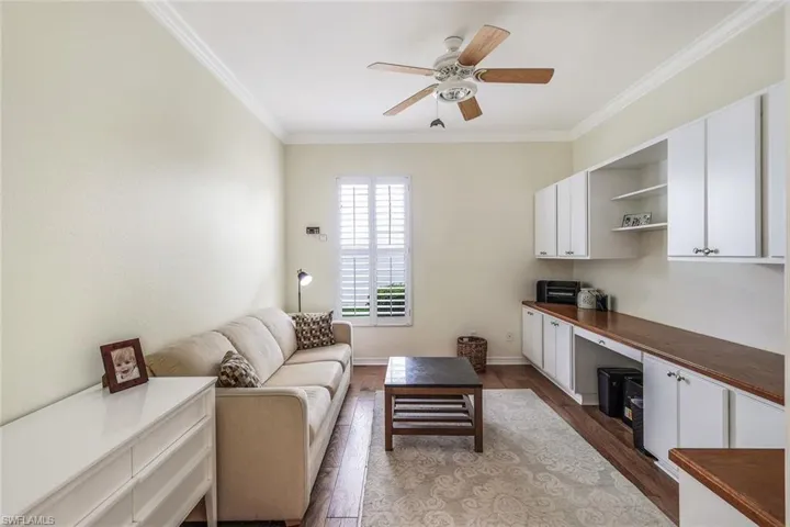 3rd Bedroom/Den/Office with built in desk/cabinets!  Crown molding, ceiling fan, and wood flooring