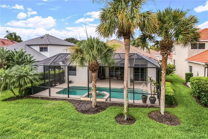 Rear view of property with a patio area, a lawn, and glass enclosure